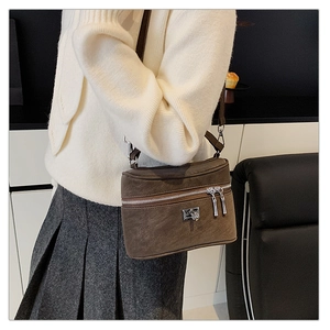 Détail du sac à bandoulière marron foncé mat avec double fermeture éclair argentée
