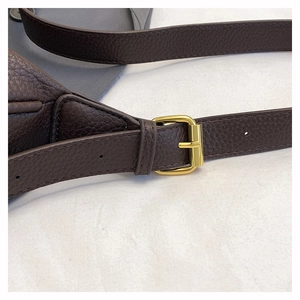 Detailed close-up of dark brown lychee grain leather strap and golden metal buckle