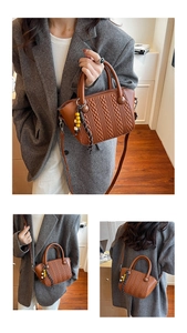 Detail of woven texture handbag featuring ethnic style bead tassels and dual top handles