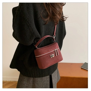 Détail du sac à main bordeaux en cuir mat avec fermoir métallique et bandoulière fine