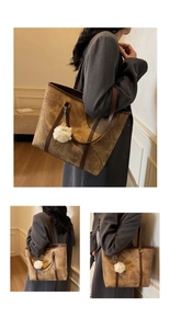 Detail view of a vintage brown tote bag with marble leather texture and plush ball charm