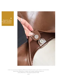 Detail of the magnetic buckle closure on a brown vintage leather tote bag