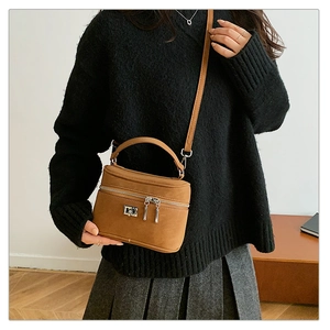 Détail du sac mallette marron vintage avec fermoir argenté et poignée supérieure
