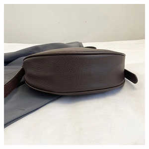 Detailed bottom view of dark brown pebbled leather crossbody bag with neat stitching
