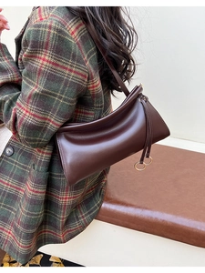 Dettaglio borsa a baguette in pelle plissettata marrone scuro con zip ad anello dorate