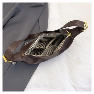 Detail view of large dark brown leather shoulder bag with striped lining and inner pocket
