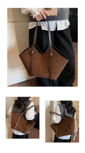 Detail view of a large vintage brown suede tote bag with V-shaped top and knot accents