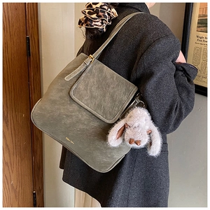 Détail du sac cabas vintage avec boucle dorée et breloque lapin en peluche gris