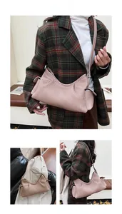 Detail of pink pleated crossbody bag featuring side pocket and adjustable shoulder strap