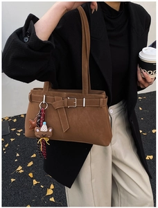 Détail du sac cabas marron vintage avec boucle décorative et pendentif ours en peluche