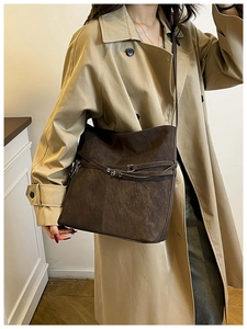 Détail du grand sac cabas marron vintage avec boucle sur un trench-coat kaki