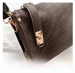 Close-up of deep brown lychee texture leather bag with elegant golden metal hardware