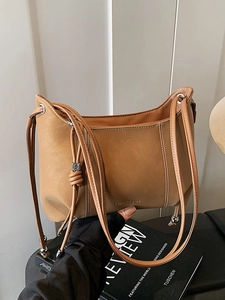 Minimalist camel PU hobo bag with vertical stitching and knotted metal bead straps