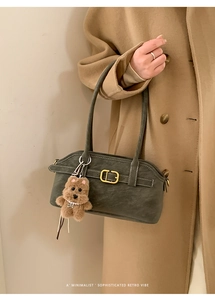 Detail of dark olive bowling bag with fuzzy bear charm and minimalist retro design