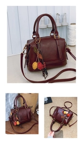 Detailansicht einer Vintage Boston Bag in Rotbraun mit einem bunten Blattanhänger-Anhänger