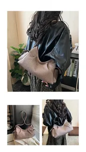 Detail of pleated tote bag featuring vertical texture and soft brown faux leather finish
