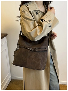 Détail du sac fourre-tout en daim marron vintage avec boucle décorative et breloque étoile