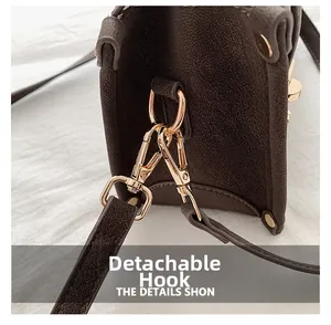 Macro shot of gold-tone swivel hook and grainy leather texture on vintage bag