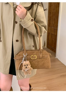 Brown matte suede shoulder bag with gold buckle and cute puppy charm on a model