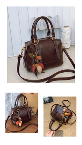 Detail der dunkelbraunen Vintage-Tasche mit bunten Blattanhängern und abnehmbarem Gurt