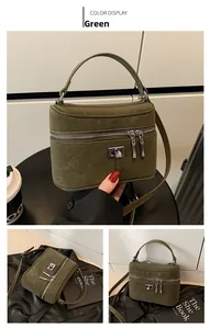 Détail d'un sac seau cylindrique vert avec fermetures éclair et verrou rotatif en métal