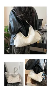Detail of white pleated shoulder bag with fine faux leather texture and metallic buckles