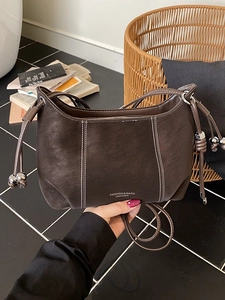 Dark brown leather shoulder bag with white contrast stitching and drawstring detail
