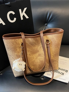 Vintage brown leather tote bag with plush charm and large capacity for daily commute
