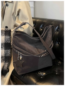 Détail du sac hobo avec boucle argentée et pendentif étoile sur daim marron foncé