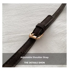 Close-up of adjustable dark brown litchi leather strap with elegant gold metal buckle