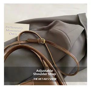 Detail of adjustable leather shoulder strap with premium gold metal buckle finish