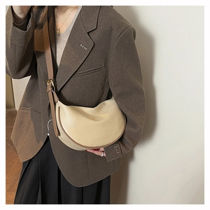Detail of soft crescent shoulder bag in creamy white leather with adjustable brown strap