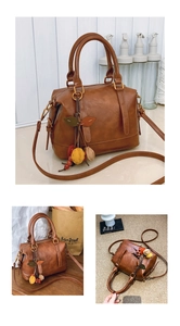 Detailansicht der braunen Boston-Tasche mit bunten Blattanhängern und verstellbarem Gurt