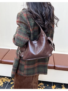Detailed outdoor view of a deep brown oil wax leather hobo bag with large capacity
