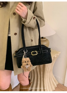Black suede underarm bag with contrast stitching and a cute plush dog charm