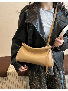 Dettaglio della borsa baguette kaki con cornice curva e nappa laterale decorativa