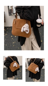 Détail d'un sac seau en daim marron avec pendentif lapin blanc pour le quotidien