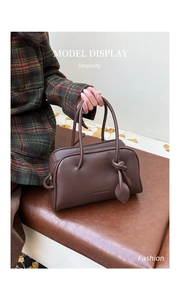 Detail der dunkelbraunen Boston-Tasche aus Narbenleder mit Knotengriff-Verzierung