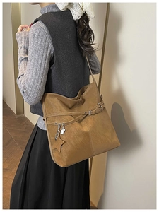 Détail d'un sac cabas marron vintage avec pendentif étoile et lanières en cuir décoratives