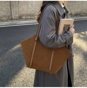 Brown suede tote bag styled with grey trench coat for casual autumn street look