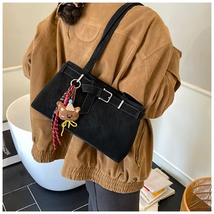 Sac fourre-tout noir en daim givré avec boucle argentée et charm ours porté par un mannequin