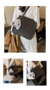 Détail d'un grand sac bandoulière rétro avec coutures contrastées et charme lapin