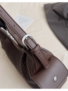 Detailed macro view of dark brown pebbled leather texture with silver metal buckle