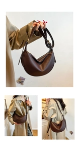 Detail of dark brown leather hobo bag with pebble grain texture and adjustable strap