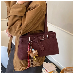 Détail du sac bandoulière bordeaux en cuir mat avec boucle et pendentif étoile chic