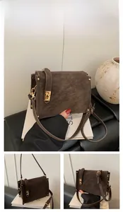 Close-up of coffee brown retro crossbody bag with suede texture and gold lock hardware
