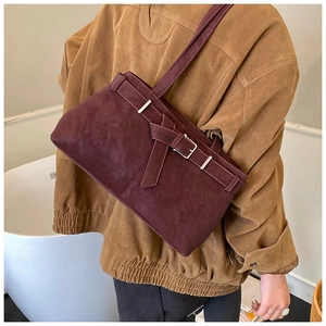 Détail du sac bandoulière en daim bordeaux mat avec boucle argentée et texture rétro