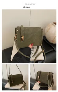 Close-up of green vintage square shoulder bag with gold metal clasp and adjustable strap