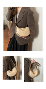 Detail of cream pebbled leather dumpling bag with brown strap and gold metal hardware