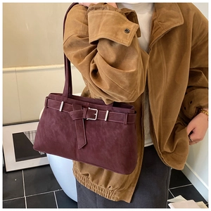 Détail d'un sac à bandoulière en cuir mat bordeaux avec boucle vintage